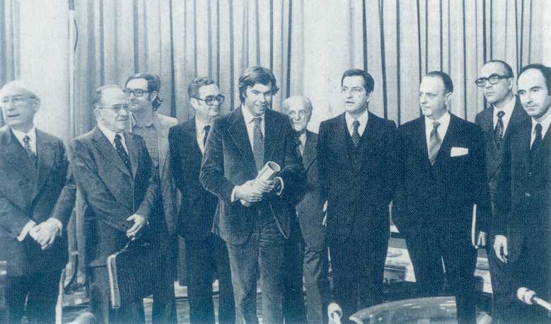 La signature du Pacte de la Moncloa (Palais) en octobre 1977. Outre, les franquistes recyclés (UCD), on y voit Felipe Gonzales, fringant au centre, Carillo et sa serviette, sur «sa gauche», avec Galvan à ses côtés (gauche), distrait. Adolfo Suarez regarde Felippe Gonzales et Manuel Fraga est intéressé par ce «nouvel homme» au costume de velours côtelé. Leopoldo Calvo Sottelo, à droite de Fraga, a le regard fixe, avec ses lunettes pesantes. Il est l'homme des chemins de fer (RENFE), de l'industrie chimique et acteur de la transition. Lepoldo Calvo Sottelo fut ministre du commerce sous Carlos Arias Navarro...